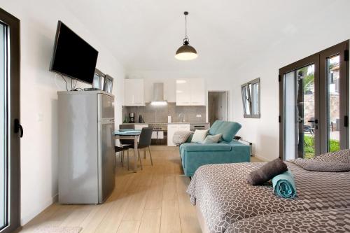 a room with two beds and a living room and a kitchen at Casa Do Vinho in Porto Santo