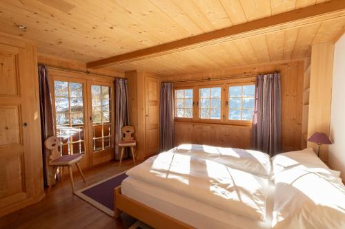 a bedroom with a bed in a room with wooden walls at Chalet Mira Golf in Sagogn