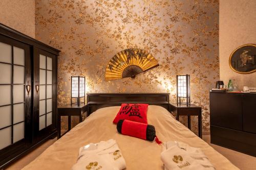 a bedroom with a bed with a red pillow on it at Willa Barbara - ProHarmonia in Lądek-Zdrój