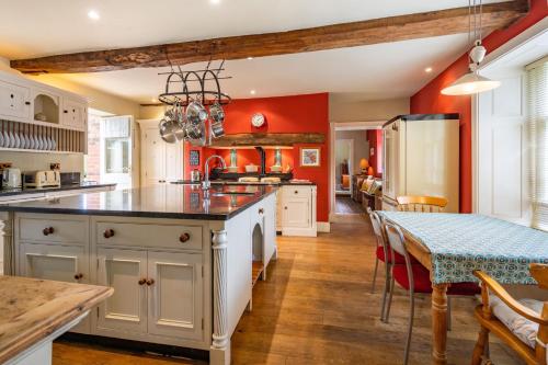 a kitchen with red walls and a table with a dining room at Ivy Farm 8 in Grimston