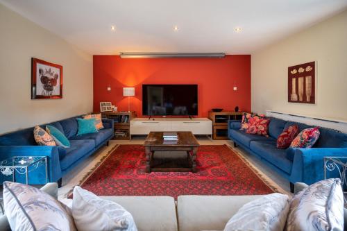 a living room with blue couches and a red wall at Ivy Farm 8 in Grimston