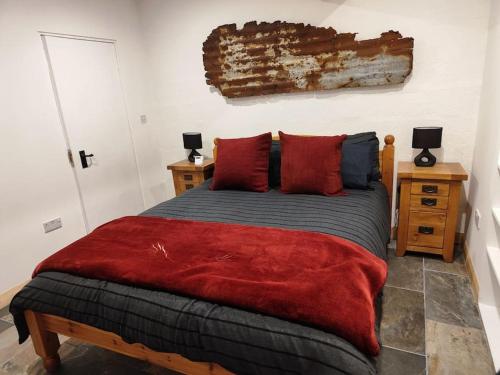 a bedroom with a large bed with red pillows at Kempies-Cozy house on the NC500 in Durness