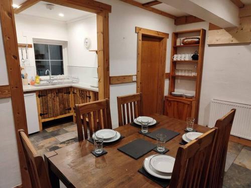 a dining room with a wooden table and chairs at Kempies-Cozy house on the NC500 in Durness