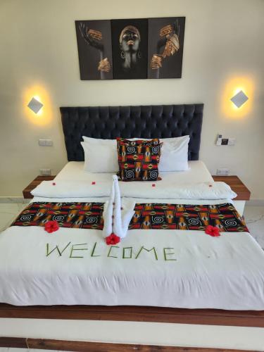 a bedroom with a bed with a welcome sign on it at Cappadocia Hotel in Nungwi