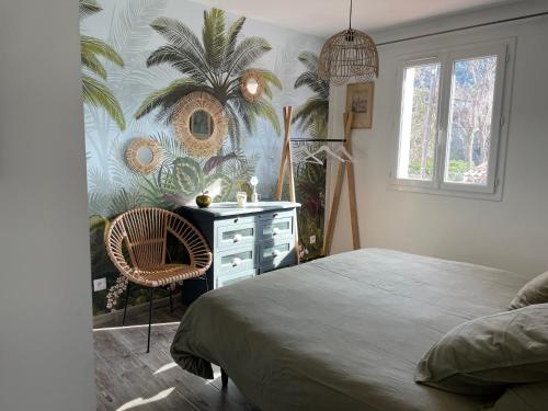 - une chambre avec un lit, une commode et une fresque murale de palmiers dans l'établissement La Calanq'Aise, à Marseille