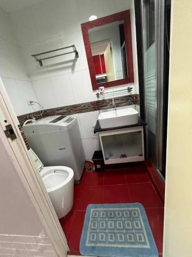 a bathroom with a toilet and a sink and a mirror at Casa de Sea residence in Manila