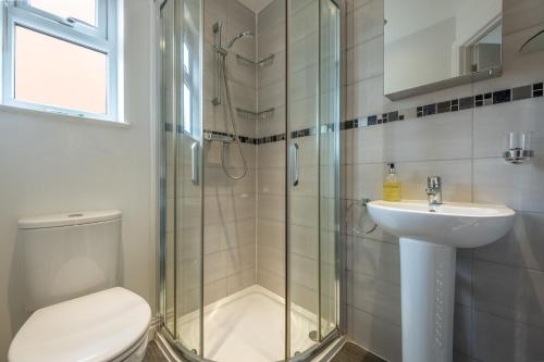 Un baño con ducha, inodoro y lavabo. en Langdale 4, en Heacham