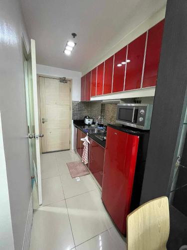 a small kitchen with red cabinets and a red refrigerator at Casa de Sea residence in Manila