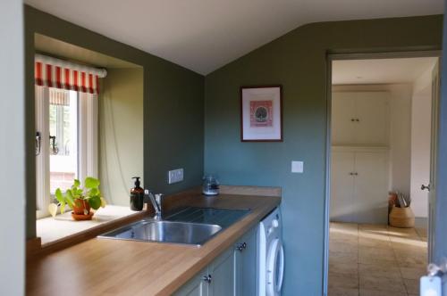 a kitchen with a sink and a counter top at Keepers Cottage F in Bircham Newton