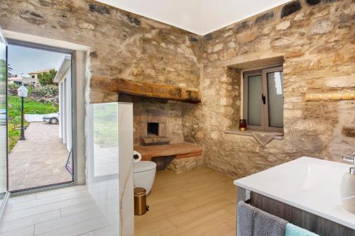 a bathroom with a toilet and a stone wall at Quinta Alcaparras in Porto Santo