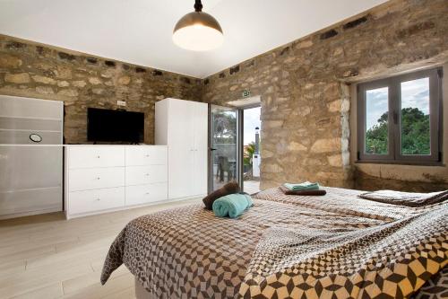 a bedroom with a large bed and a stone wall at Quinta Alcaparras in Porto Santo