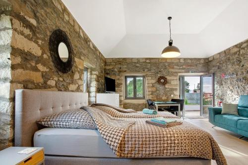 a bedroom with a bed and a stone wall at Quinta Alcaparras in Porto Santo