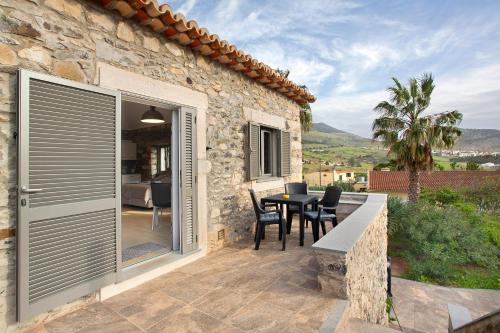 a stone house with a patio with a table and chairs at Quinta Alcaparras in Porto Santo