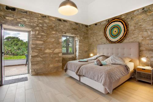 a bedroom with a bed and a stone wall at Quinta Alcaparras in Porto Santo