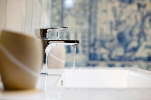 a bathroom sink with a faucet and a cup of water at Quinta Alcaparras in Porto Santo