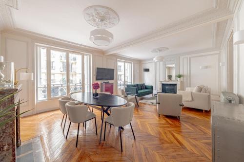 un salon avec une table et des chaises dans l'établissement Parisian Elegance 2bedr in the 16th, à Paris