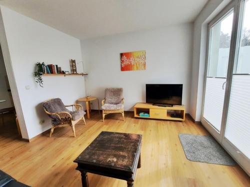 a living room with a flat screen tv and chairs at Ferienwohnung 9 in der Strandstraße in Müritz
