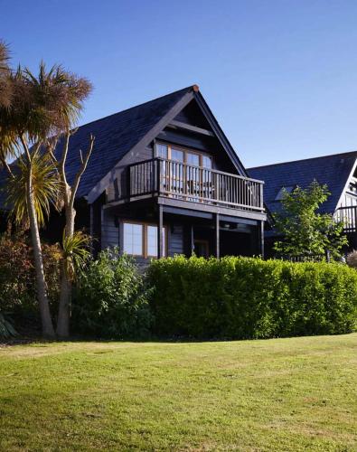 a large house with a balcony and a palm tree at Gwel an Mor in Portreath
