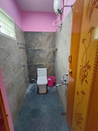 baño con aseo y techo rosa en NIVAS HILL VIEW APARTMENTS en Tiruvannāmalai