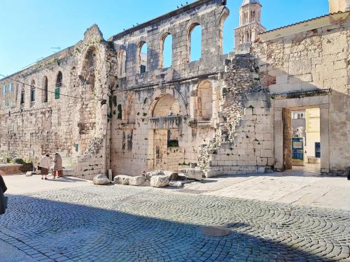 an old stone building with a cobblestone street in front at Split It Hostel in Split