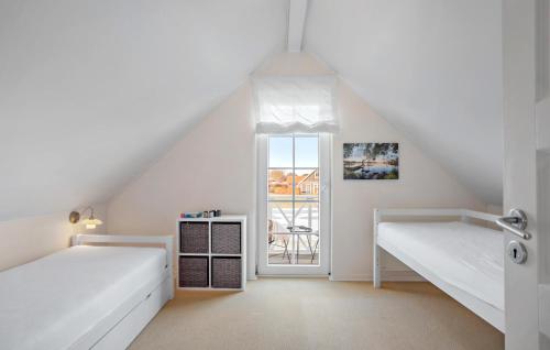 een slaapkamer op zolder met 2 bedden en een raam bij Stunning Home In Brenderup Fyn With Wifi in Bro
