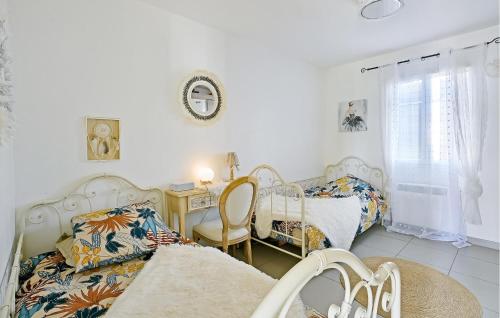 a bedroom with two beds and a table and a desk at 3 Bedroom Stunning Home In Bagnols-sur-cze in Bagnols-sur-Cèze