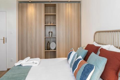 a bedroom with a white bed with red and blue pillows at Baleal Beachfront in Ferrel