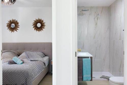 a bedroom with a bed and a bathroom with a mirror at Casa De Pedra in Porto Santo