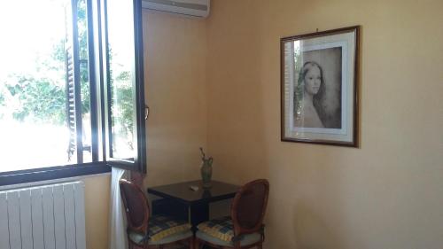 een kamer met een tafel en twee stoelen en een foto bij B&B Castellazzo in Paceco