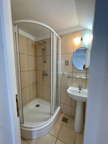 a bathroom with a shower and a sink at Casa Fenyves Vendégház in Băile Tuşnad