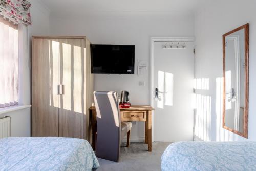 a bedroom with a desk and a bed and a table at Apple House Wembley in Barnet