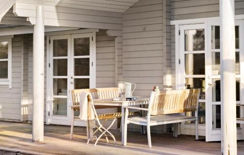 a porch with a table and chairs on a house at 4 Bedroom Lovely Home In Sjællands Odde in Yderby