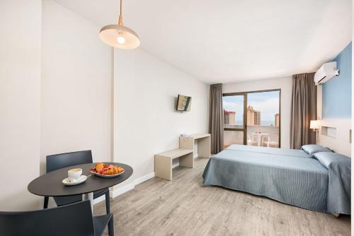 a bedroom with a bed and a table with a bowl of fruit at Veramar Aparthotel in Fuengirola