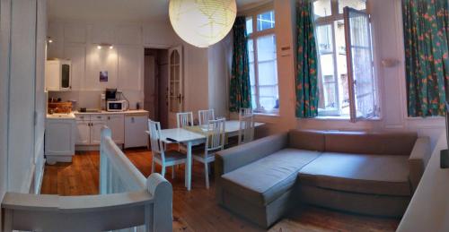 a living room with a couch and a table and a kitchen at Dieppe Coeur de Ville in Dieppe