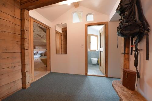 - un couloir menant à une salle de bains pourvue de toilettes dans l'établissement Casa Fausta Capaul, à Brigels