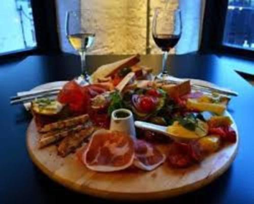 a plate of food on a table with two glasses of wine at Cosy City Apartment in Cork