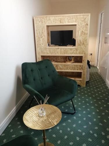a living room with a green chair and a table at Cosy City Apartment in Cork