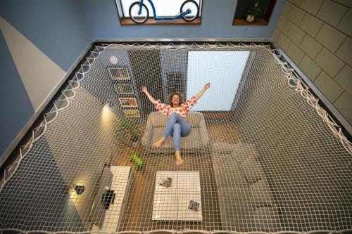 a woman is laying in a net in a room at Hammock Heights! Hot Tub,Private Garage,CityCentre in Manchester