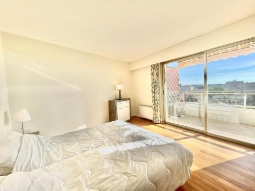 1 dormitorio con cama y ventana grande en Vezelay, by Welcome to Cannes en Cannes
