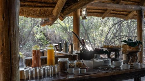 una mesa con tarros y otros artículos en ella en Mashatu Tent Camp, en Lentswelemoriti