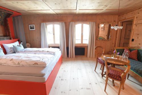 a bedroom with a bed and a table and chairs at Casa Fausta Capaul in Brigels