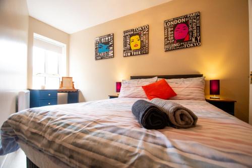 um quarto com uma cama com almofadas e cartazes na parede em Peak View Apartment Main Beach em Bundoran