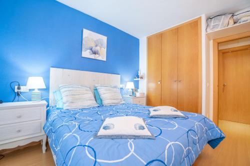 a blue bedroom with a bed with blue walls at Apartamento ROYAL MARINE in Empuriabrava