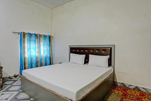1 dormitorio con 1 cama grande con sábanas blancas en OYO Riddhi Siddhi Hotel And Marriage Garden 