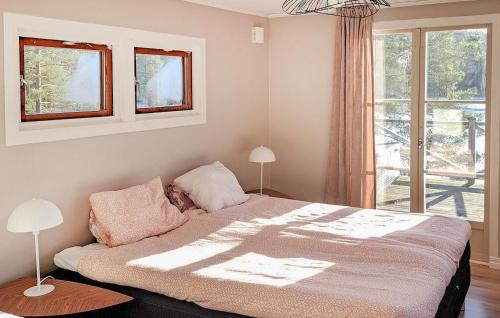 a bedroom with a large bed with a window at Gorgeous Home In Mariannelund With House Sea View in Mariannelund