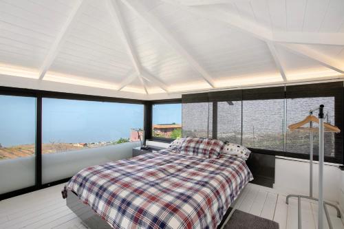 um quarto com uma cama num quarto com janelas em Spr Finca em Sauzal