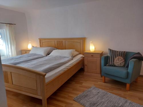 een slaapkamer met een bed en een blauwe stoel bij Altstadtliebe Salzuflen in Bad Salzuflen