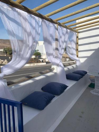 a white bench with blue pillows on a balcony at Love story in Mala