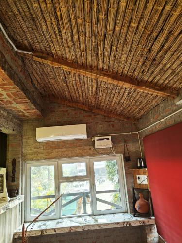 a room with a window and a wooden ceiling at Shobhayan inn, airport railway station pickup free in Ayodhya