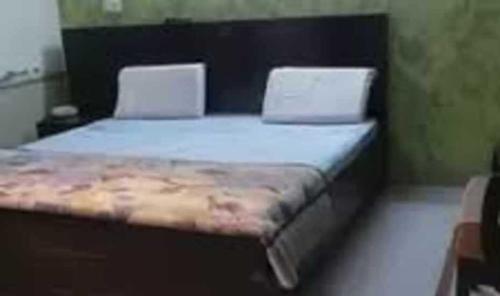 a bed in a room with two white beds at OYO Abhi Hotel in Meerut
